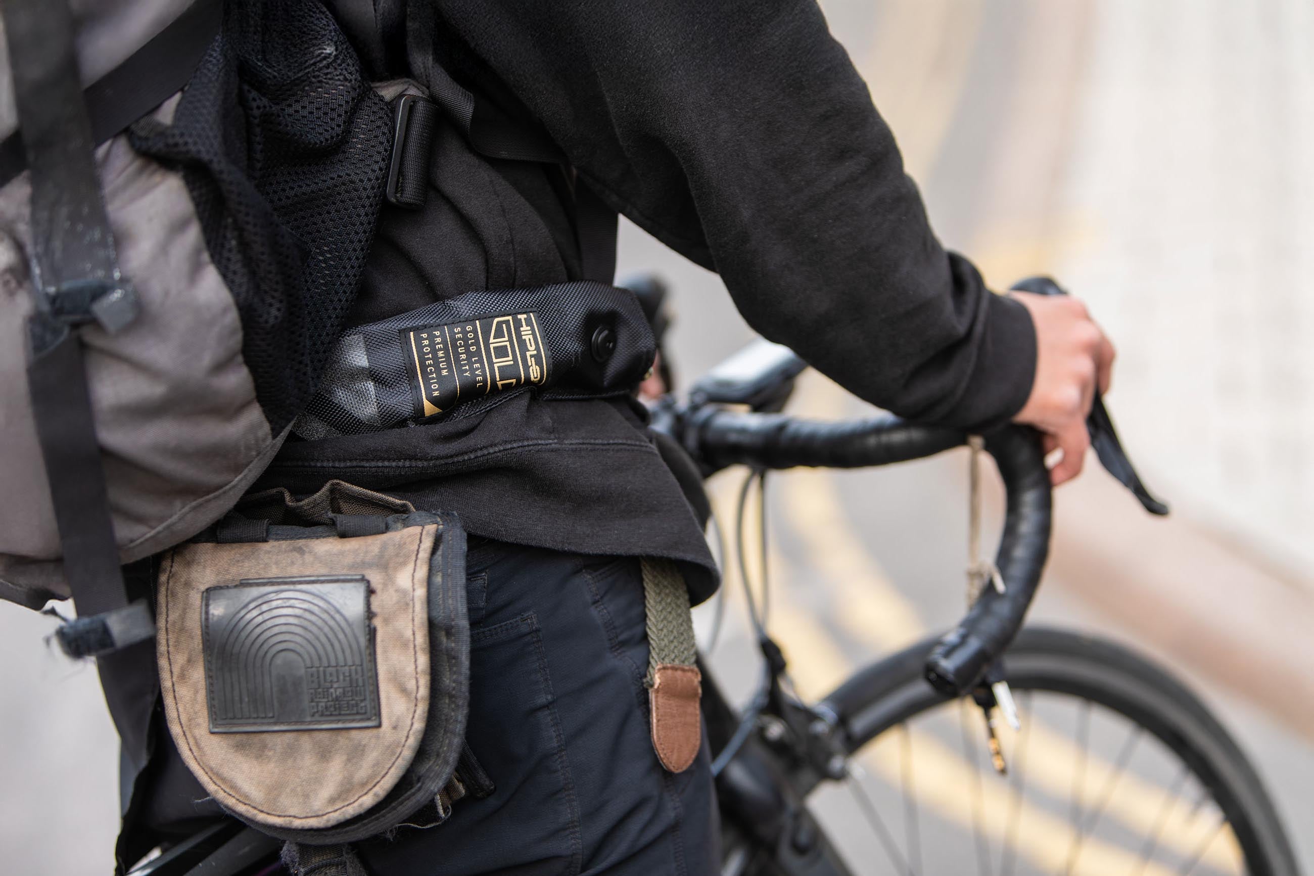 person stood over road bike with a bike lock chain lock attached around waist