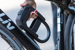 Woemen removing Hiplok DX D lock bike lock from D lock frame mount on down tube