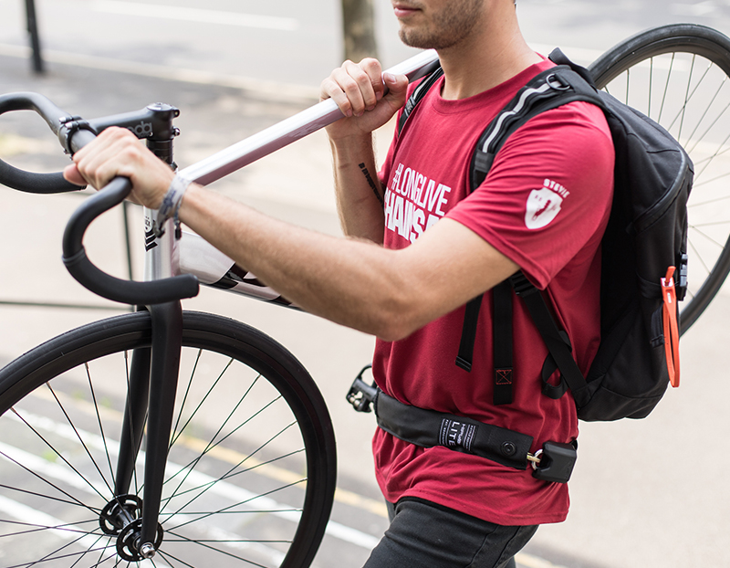 Man wearing Hiplock LITE around his waist while carrying his bicycle