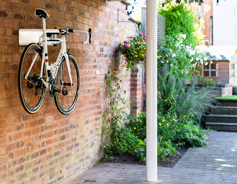 Bike locked with AIRLOK bike hanger in a garden on a brick wall